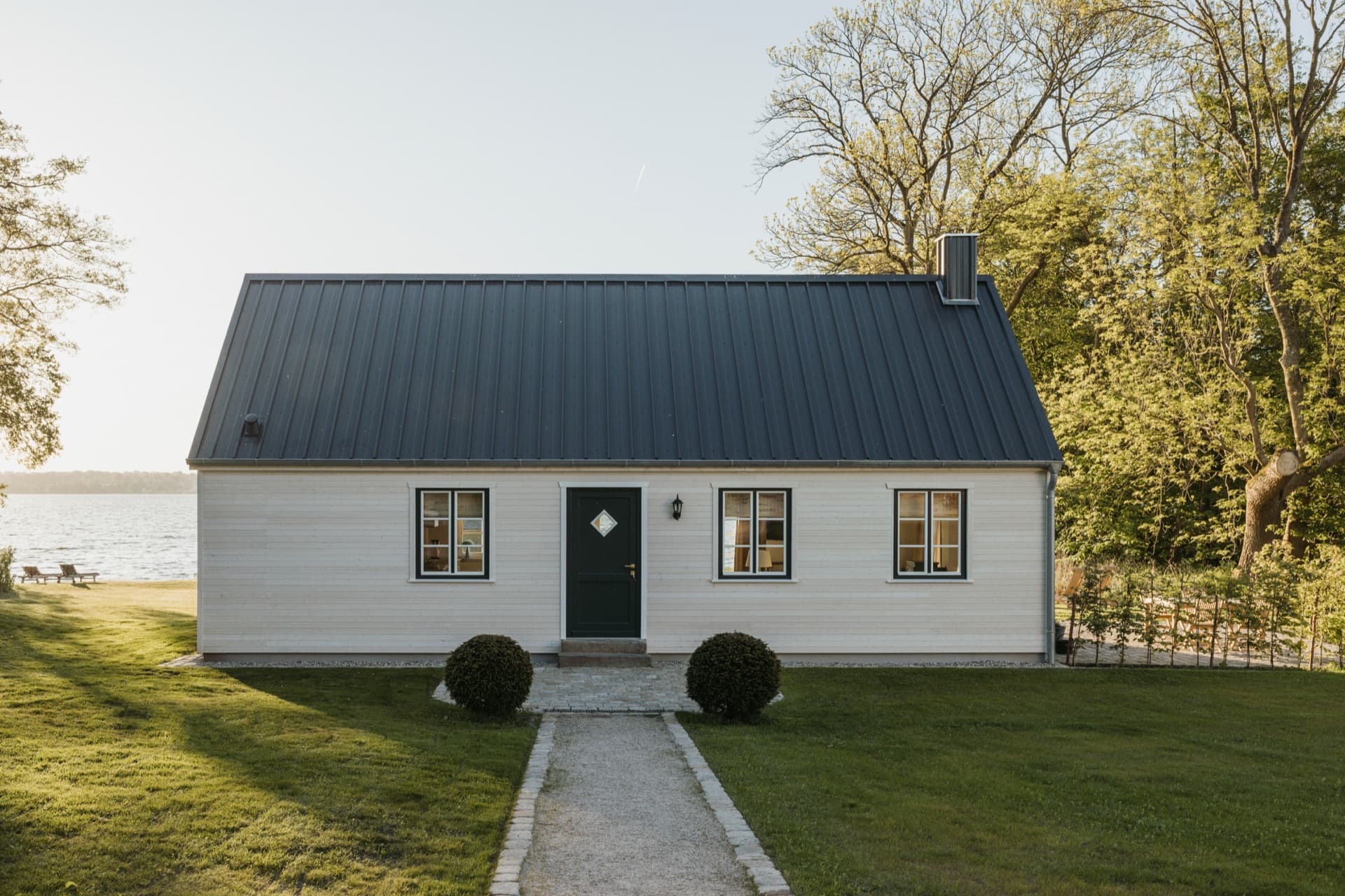 Seehaus am Plöner See — weißes Holzhaus mit dunklem Pultdach